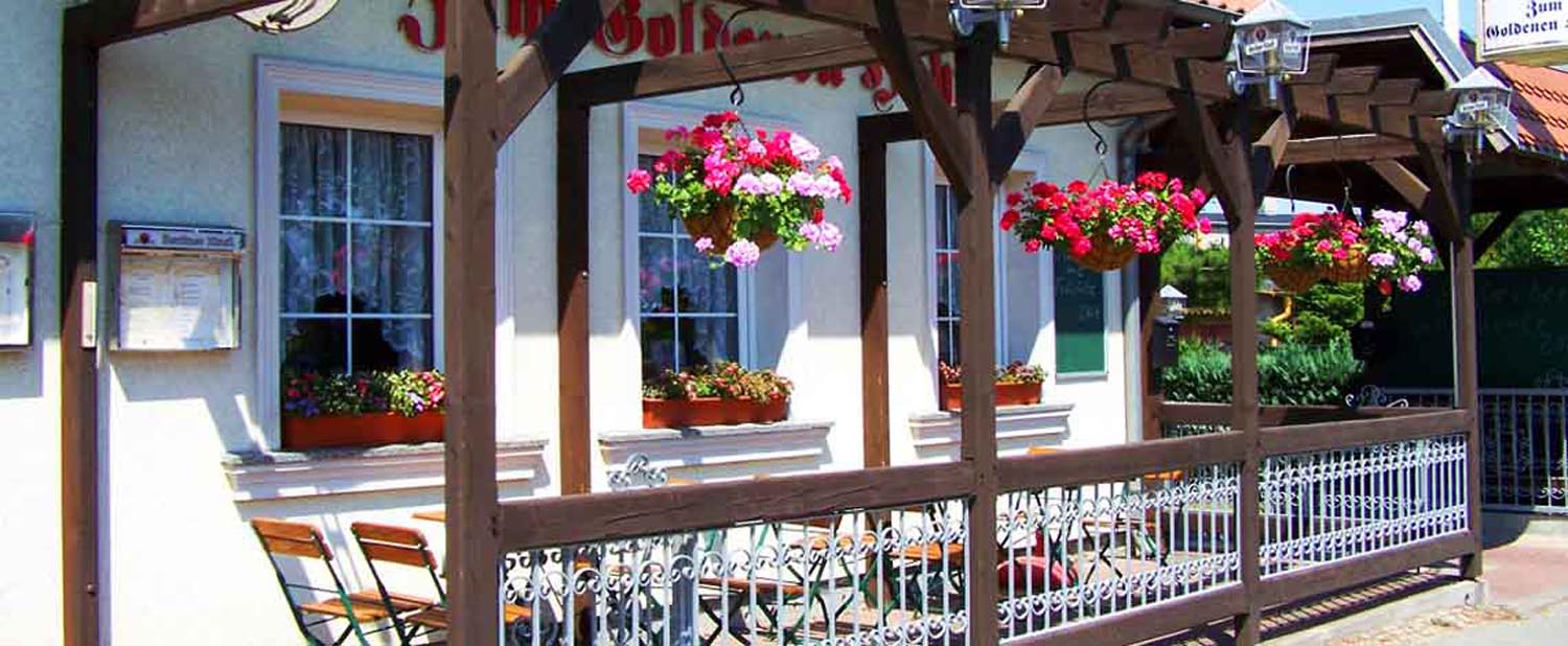 Aussenansicht Lokal mit Bluemenampeln